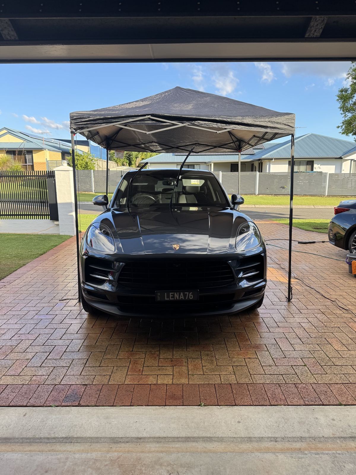 Front of a black Porsche Macan under the mobile gazebo after detailing