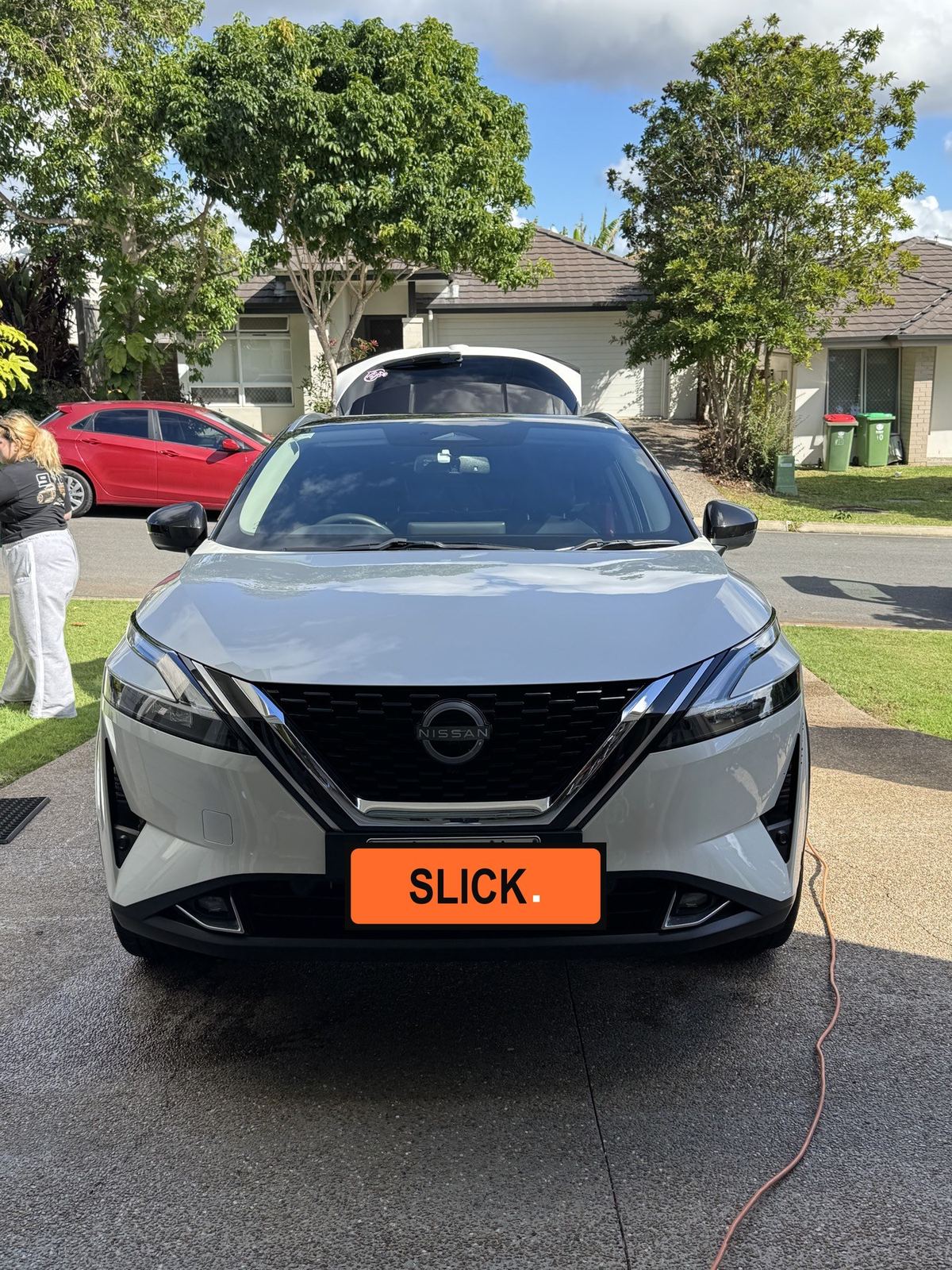Clean white Nissan detailed kerbside on a residential street, front view